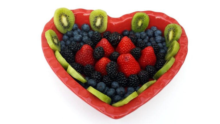 Heart-shaped bowl filled with strawberries, blueberries, blackberries and kiwi slices