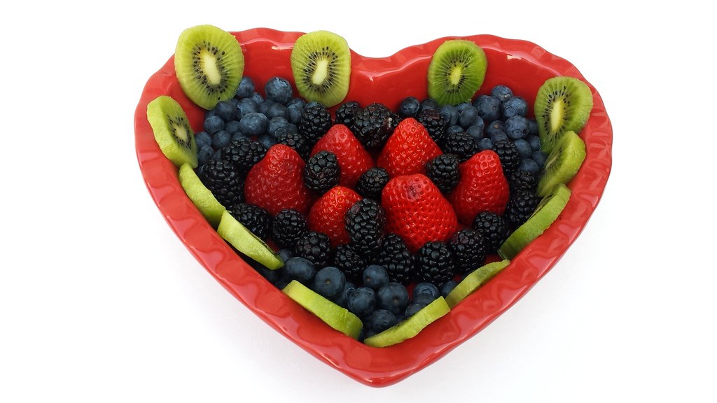 Heart-shaped bowl filled with strawberries, blueberries, blackberries and kiwi slices
