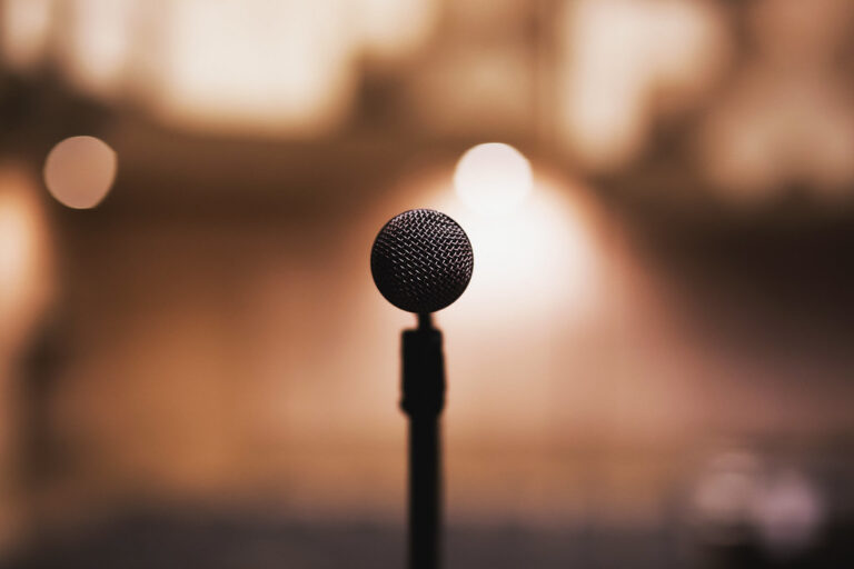 Microphone on a stand against a warm, softly blurred background