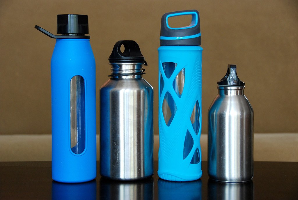 Reusable water bottles in blue and steel lined up on a table