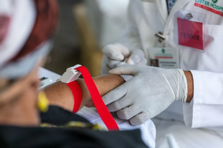 Health worker in gloves preparing a patient arm for a routine blood test