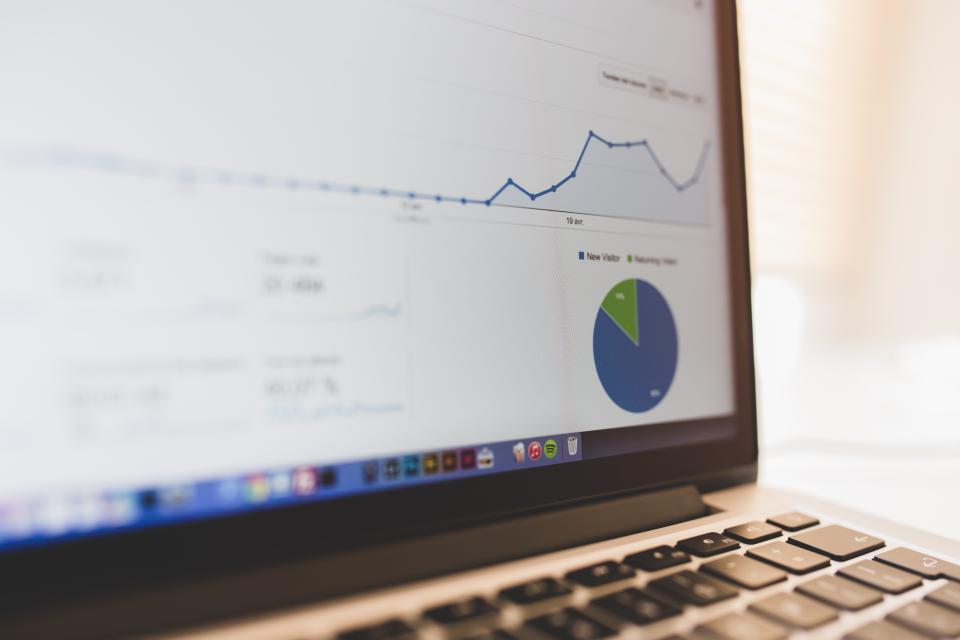 Laptop screen showing a website analytics line graph and pie chart