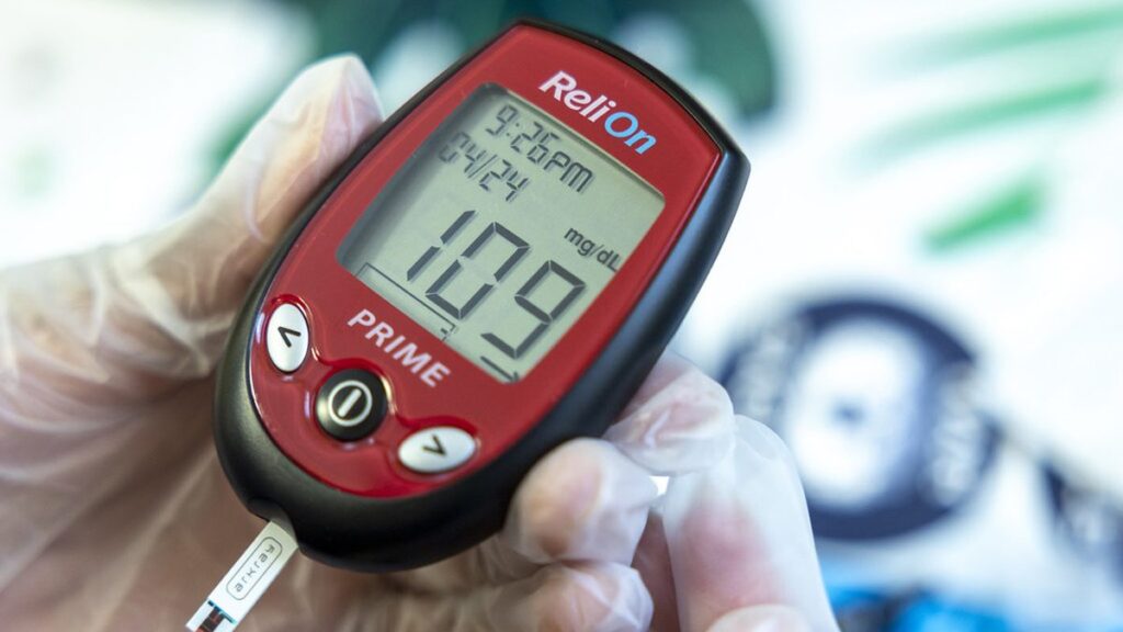 Adult checking blood sugar with a glucose meter at home